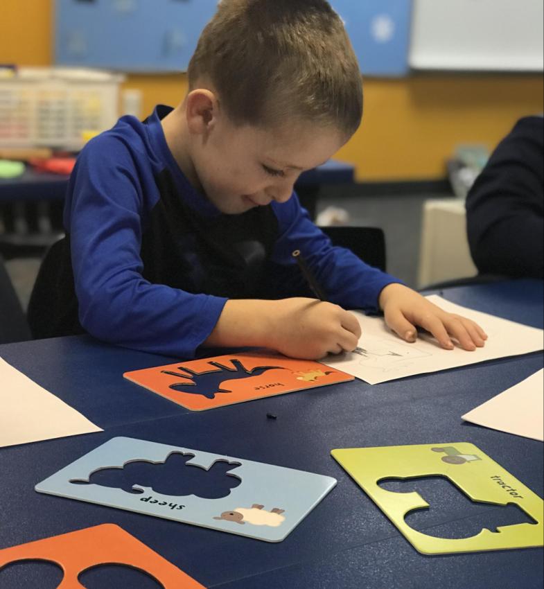 preschool student using stencils