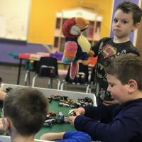 preschool students playing with cars and puppets
